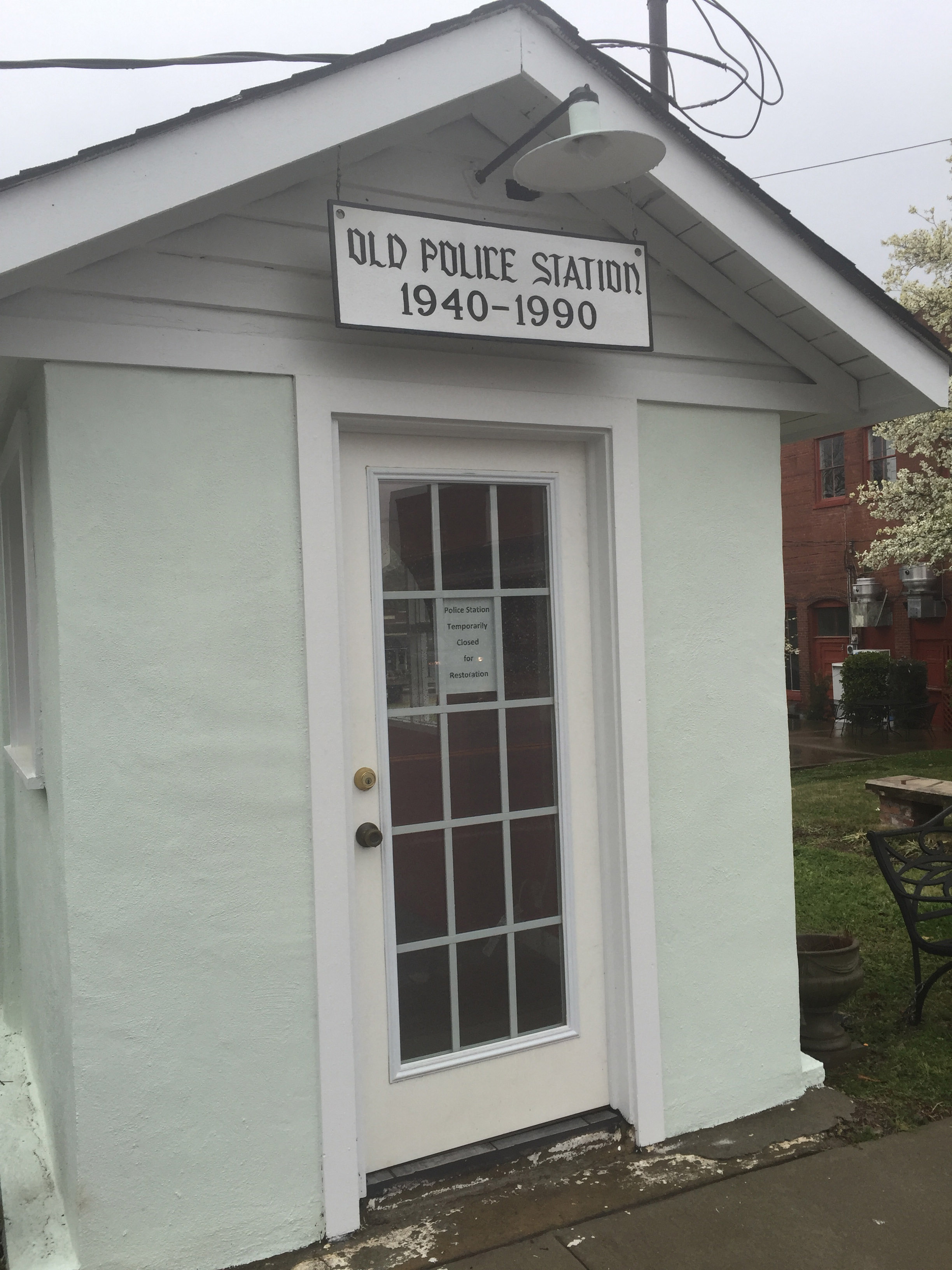 Front of old police station with sign that says, "1940-1990."
